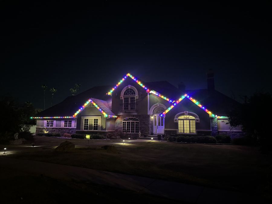 Home with a colorful roofline and stake lights along the front beds